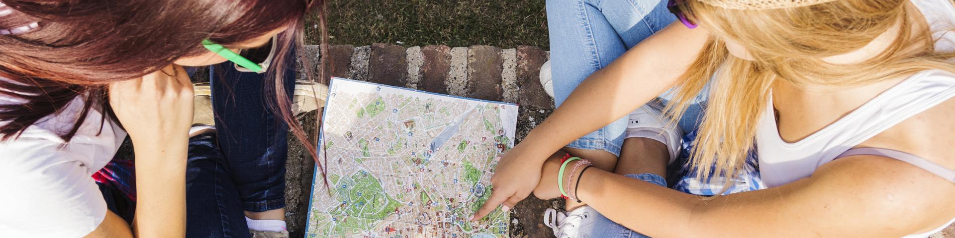 Vista en ángulo alto de dos excursionistas buscando la dirección en un mapa