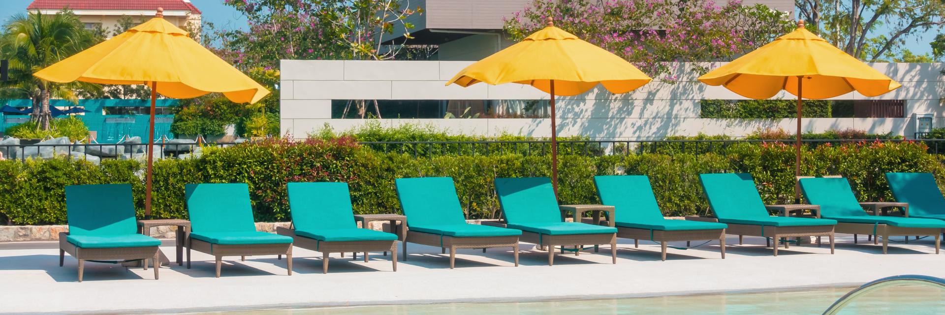 Umbrella And Chair Around Swimming Pool