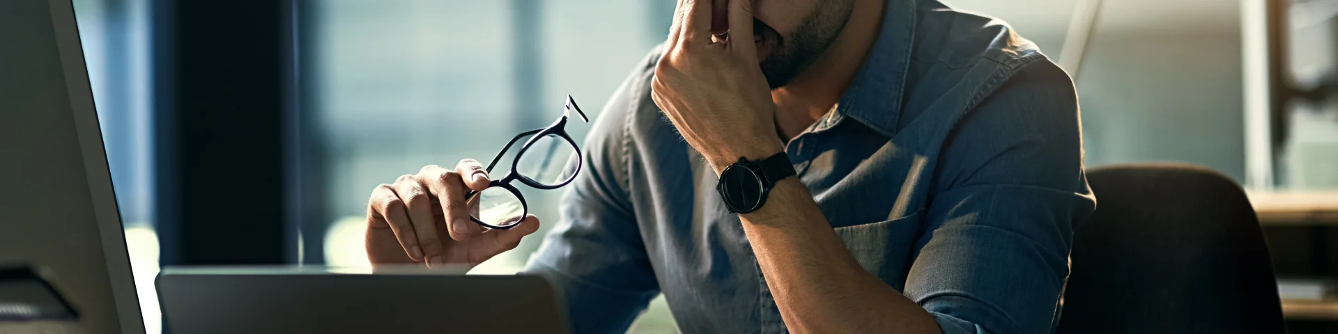 Struggling with occupational stress. Shot of a young businessman experiencing stress during a late night at work