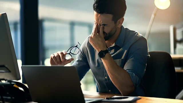 Struggling with occupational stress. Shot of a young businessman experiencing stress during a late night at work