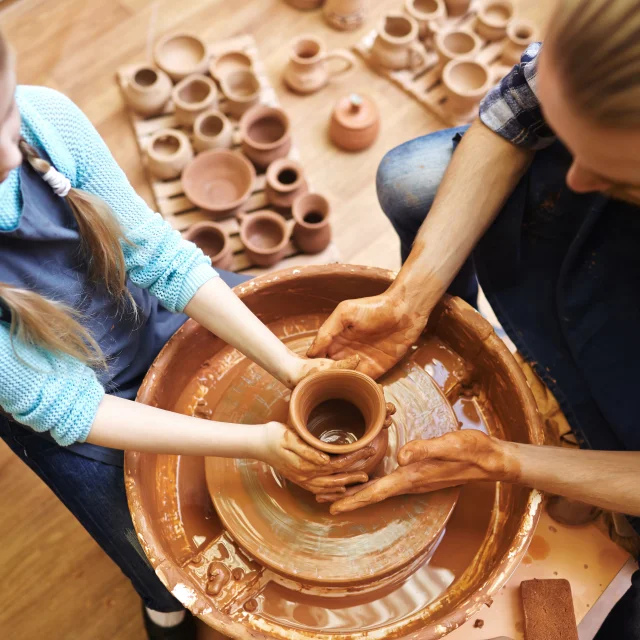 Potter and his daughter making new clay jug