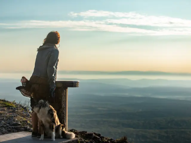 Une femme et son chien observent le lever du soleil de la garrigue depuis Mont Bouquet