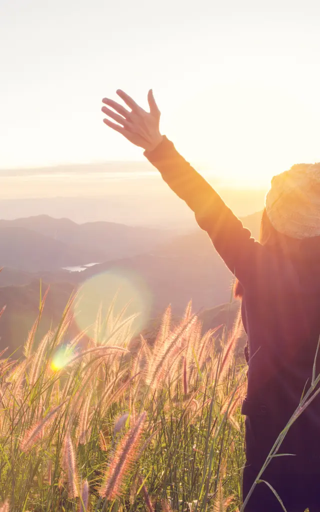 Une femme épanouie devant le joli lever du soleil.