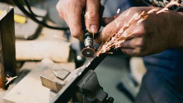 Artisan en train de graver une lame de couteau