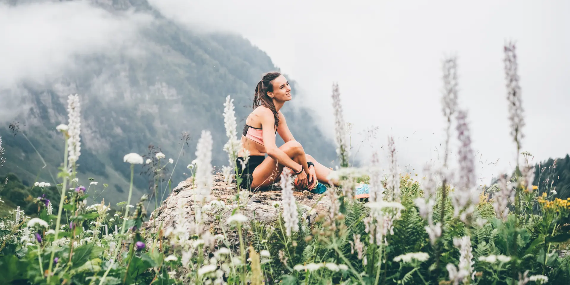 Sport woman relaxing on mountain cliff above the clouds. Alone travel healthy lifestyle. Healthy life Concept.
