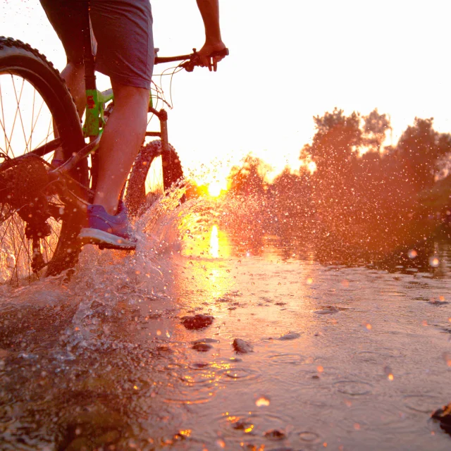 LENSVLAKTE: Sportman rijdt op zijn fiets in de ondiepe beek t