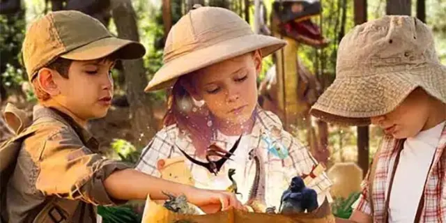 Publicité pour la chasse au trésor de dinopédia mettant en avant trois enfants qui regarde une carte
