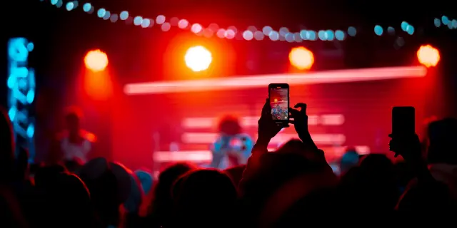 Close up von Videoaufnahmen mit dem Smartphone während eines Konzerts. Getöntes Bild