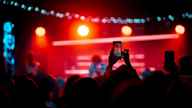 Close up of recording video with smartphone during a concert. Toned picture