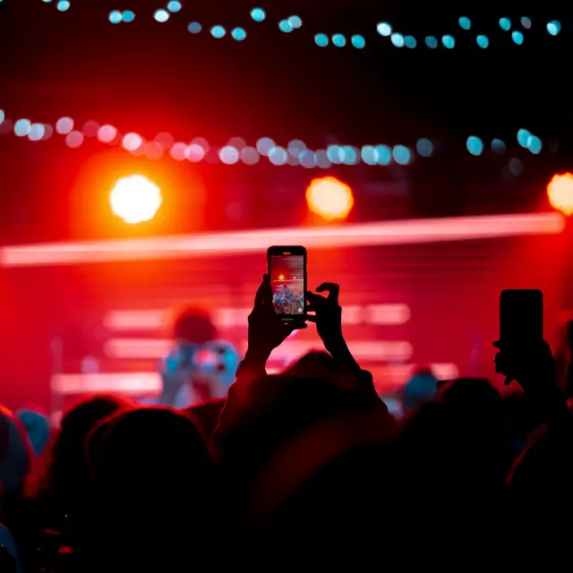 Close up von Videoaufnahmen mit dem Smartphone während eines Konzerts. Getöntes Bild