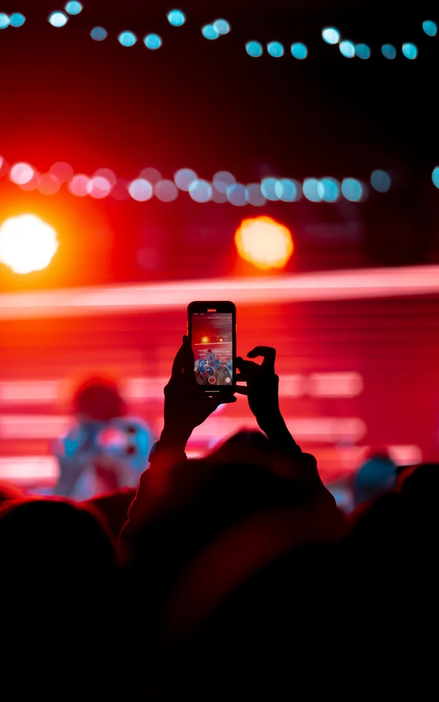 Close up of recording video with smartphone during a concert. Toned picture