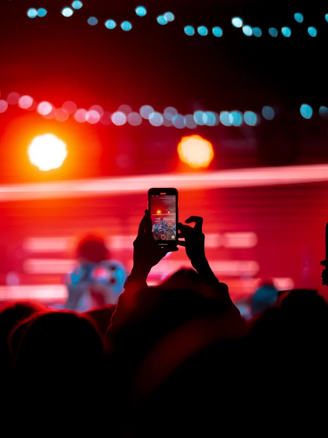 Close up von Videoaufnahmen mit dem Smartphone während eines Konzerts. Getöntes Bild