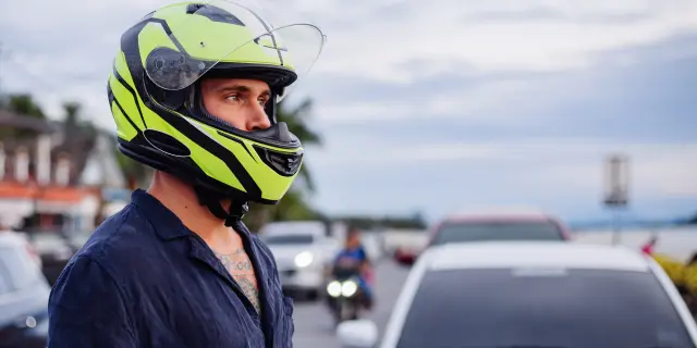 Portrait D Homme Motard En Casque Jaune Sur Le Cote De La Route Tres Frequentee En Thailande Au Coucher Du Soleil Min