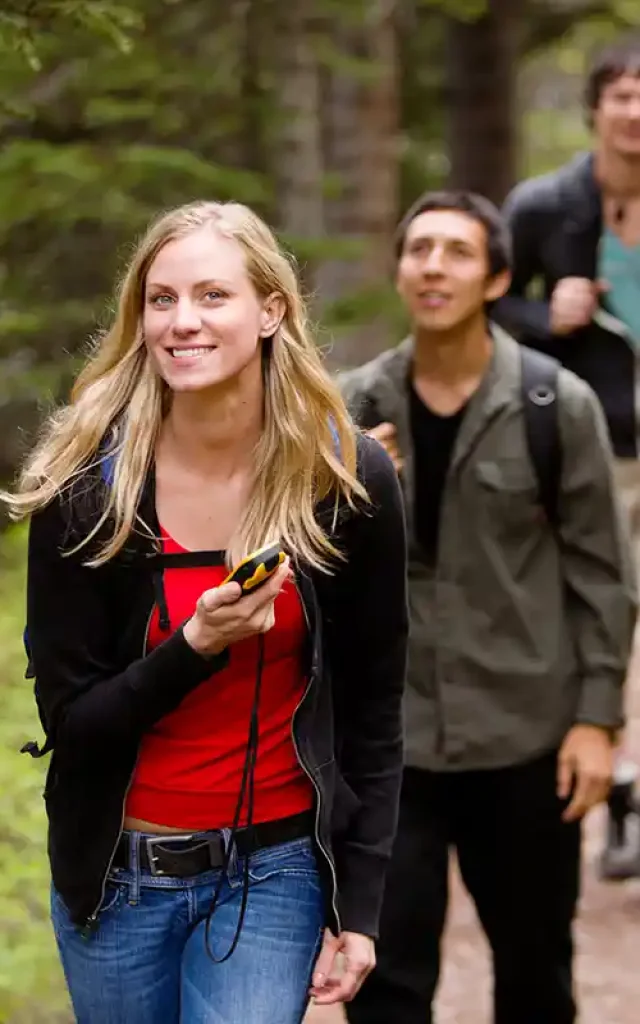 Femme avec un GPS en main sur un chemin de Chartreuse pendant une session de geocaching