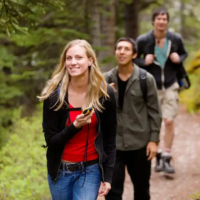 Femme avec un GPS en main sur un chemin de Chartreuse pendant une session de geocaching