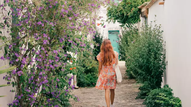 Young_woman_promoting_in_a_paved_and_flowered_arena_in_a_village_on_the_Isle_of_Re_40035