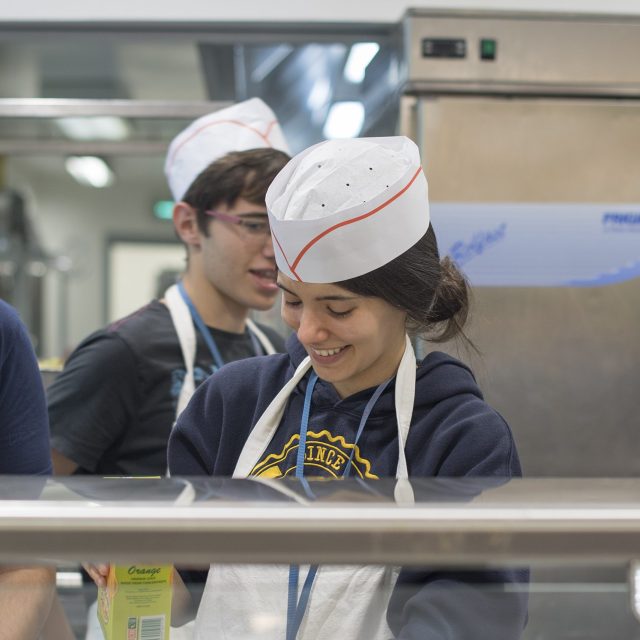 Des bénévoles servent les repas au grand restaurant