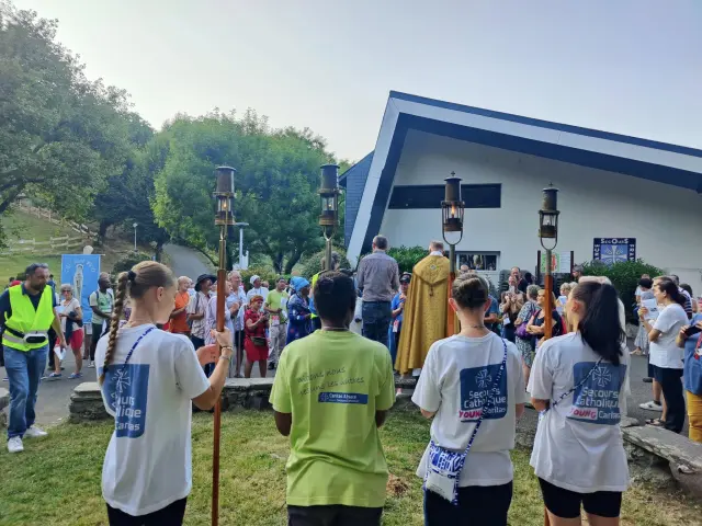 4 junge Freiwillige (young caritas) halten die Fackeln für die Marienprozession.