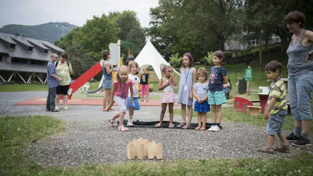 Famiglie che giocano nell'area giochi per bambini