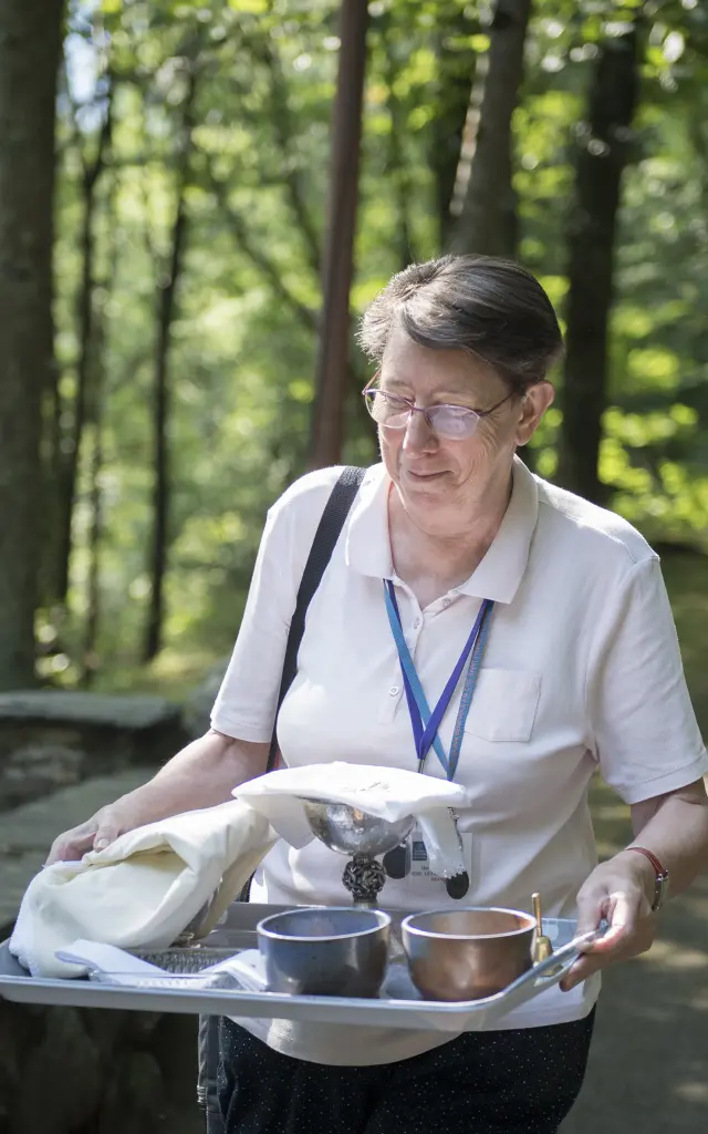Une bénévole du service des Lieux de cultes prépare la messe à la Cathédrale de Verdure