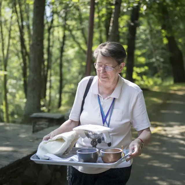 Een vrijwilliger van de eredienst bereidt zich voor op de mis in de Cathédrale de Verdure