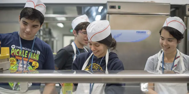 Les bénévoles au service Restauration servent les repas au grand restaurant