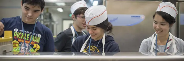 Les bénévoles au service Restauration servent les repas au grand restaurant