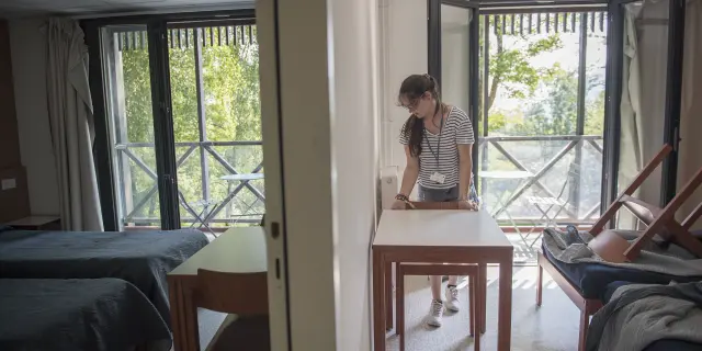 Een vrijwilliger maakt een kamer klaar in een paviljoen