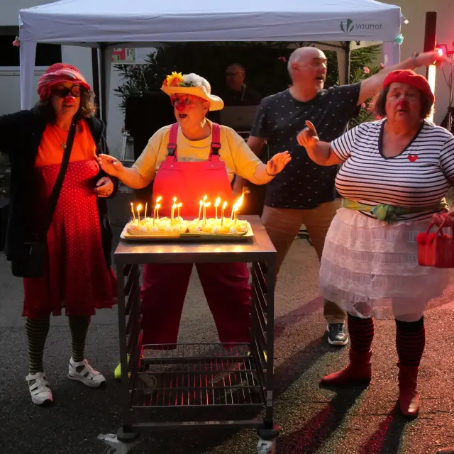 Les clowns du Réseau Saint Laurent soufflent les bougies du gâteau d'anniversaire de la Cité Saint-Pierre