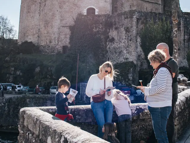 Enfants résolvant les énigmes du jeu de piste Clisson avec vue sur le château de Clisson