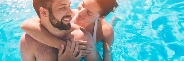 Jeune couple dans la piscine sous le soleil