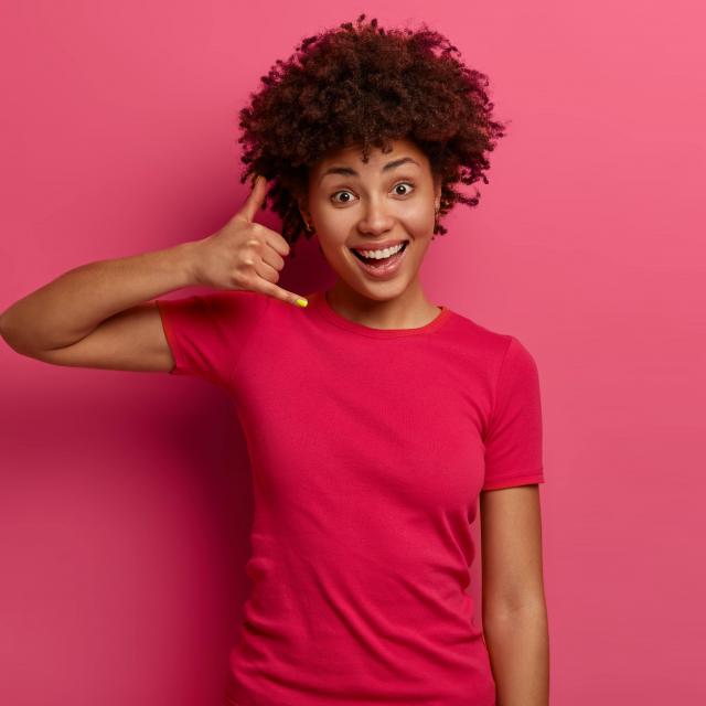Femme mimant le geste de téléphoner