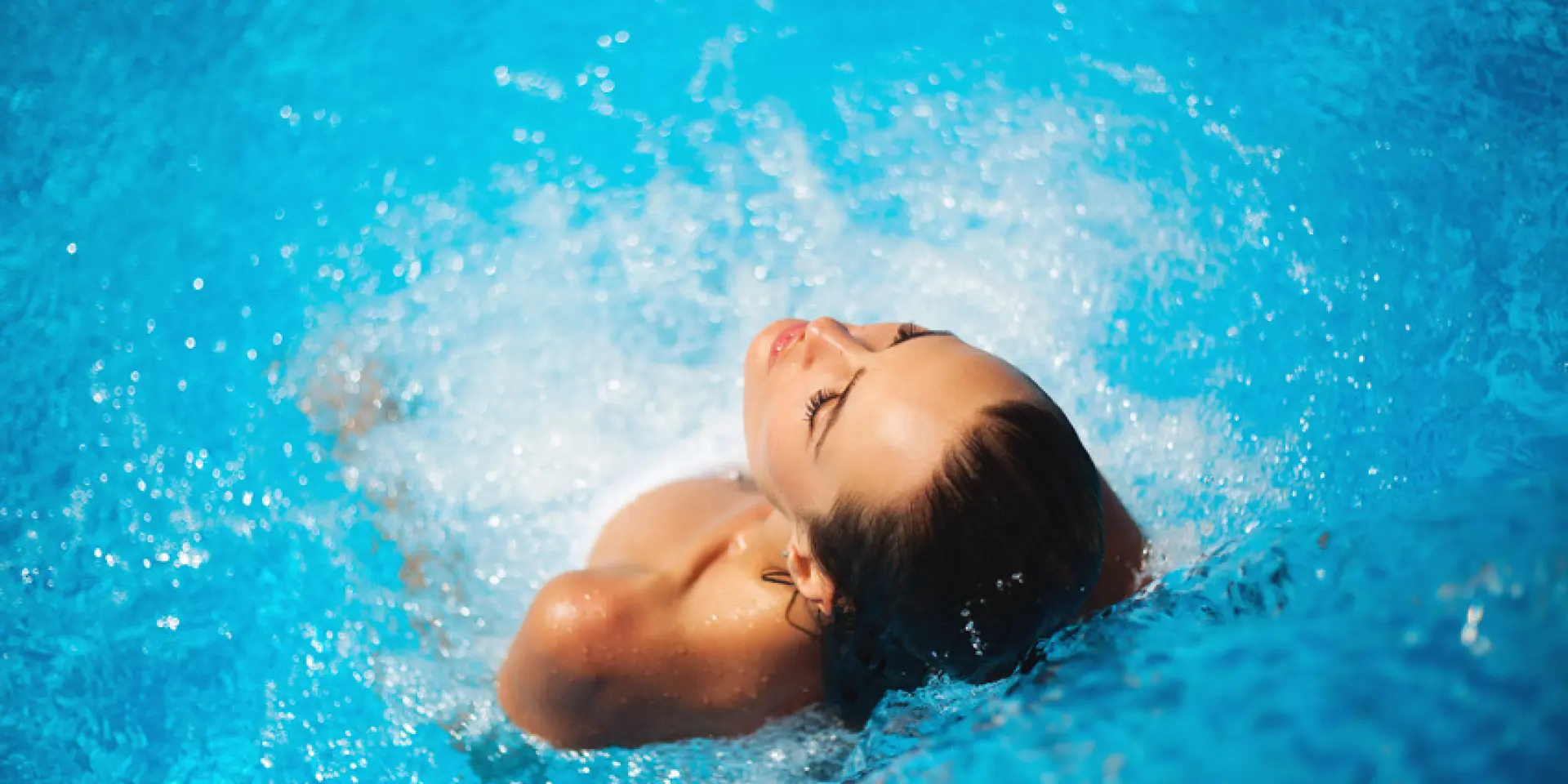 Jeune femme se prélassant dans une piscine à jets