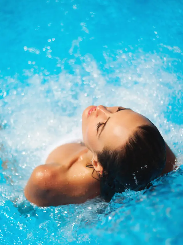 Jeune femme se prélassant dans une piscine à jets
