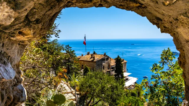 Eze, France - August 1, 2022: Chateau Eza hotel on slope of medieval fortress castle hill on top of historic town of Eze at French Riviera Coast of Mediterranean Sea