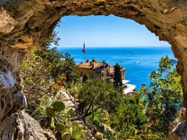 Eze, France - August 1, 2022: Chateau Eza hotel on slope of medieval fortress castle hill on top of historic town of Eze at French Riviera Coast of Mediterranean Sea