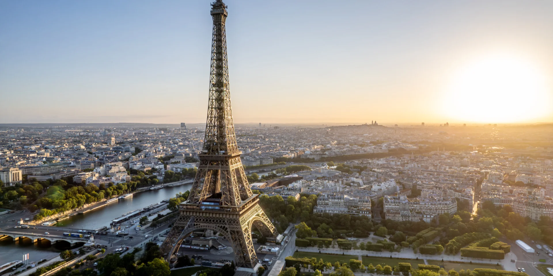 Aerial view of Paris, France, overlooking the famous Eiffel Tower, sunrise in the background.