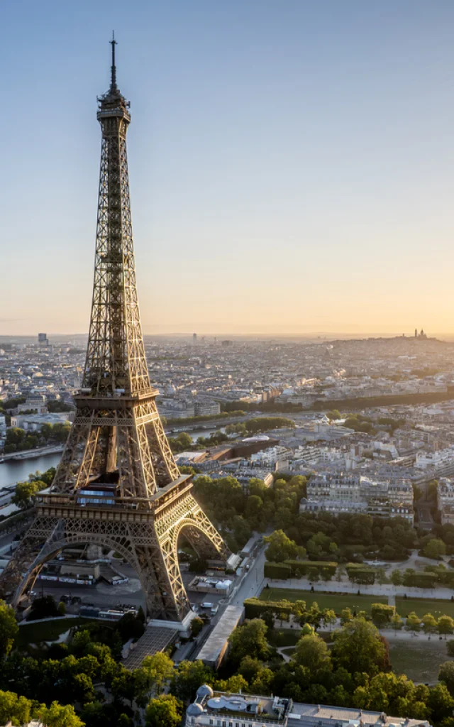 Aerial view of Paris, France, overlooking the famous Eiffel Tower, sunrise in the background.