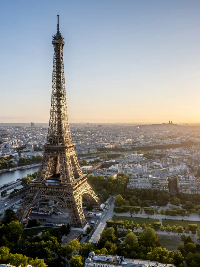 Aerial view of Paris, France, overlooking the famous Eiffel Tower, sunrise in the background.