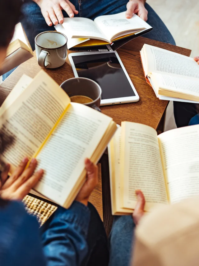 Diverse group of friends discussing a book in library.