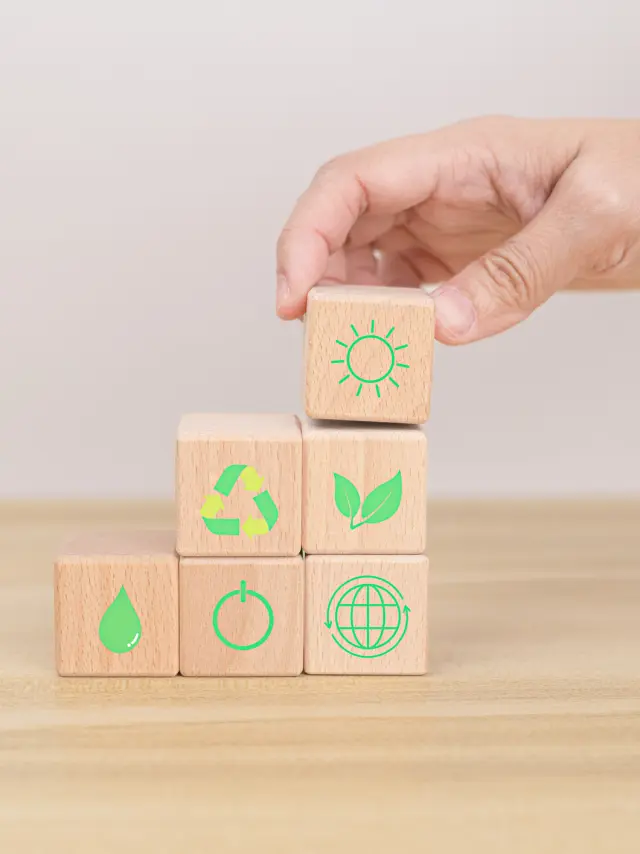 Hand arranging wood block. Recycle symbol Green sun, leaves, water drops, globe, on-off switch on the wooden cube. World environment and earth day. save world concept. taking care nature and ecology.