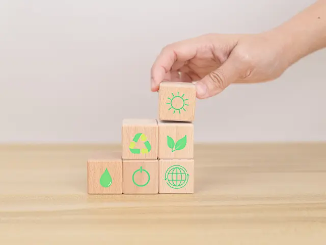 Hand arranging wood block. Recycle symbol Green sun, leaves, water drops, globe, on-off switch on the wooden cube. World environment and earth day. save world concept. taking care nature and ecology.