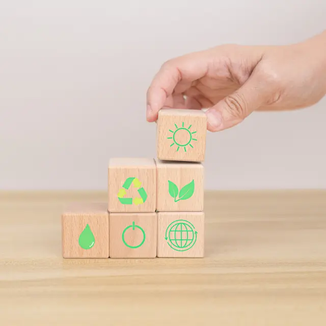 Hand arranging wood block. Recycle symbol Green sun, leaves, water drops, globe, on-off switch on the wooden cube. World environment and earth day. save world concept. taking care nature and ecology.