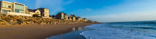 Voiliers amarrés dans un port avec des bâtiments en arrière-plan au coucher du soleil