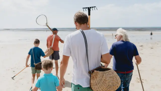 Adulte et enfant lançant un frisbee sur une plage ensoleillée
