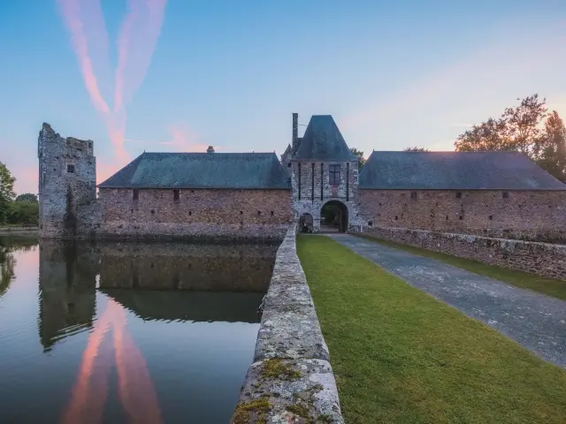 Château de Gratot avec douves au coucher du soleil