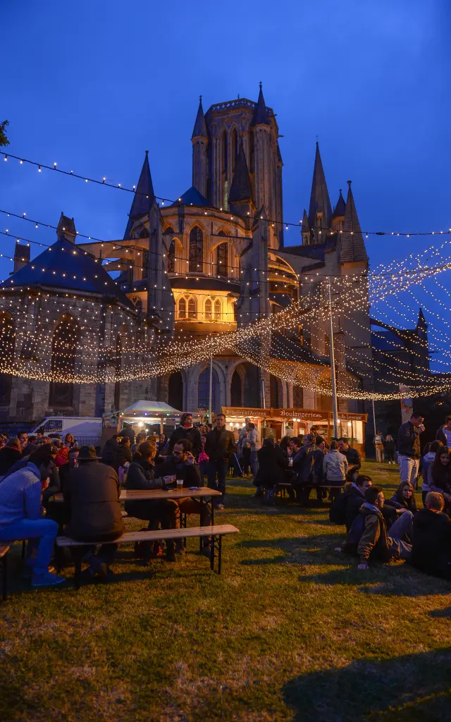 Fête de nuit devant une cathédrale illuminée