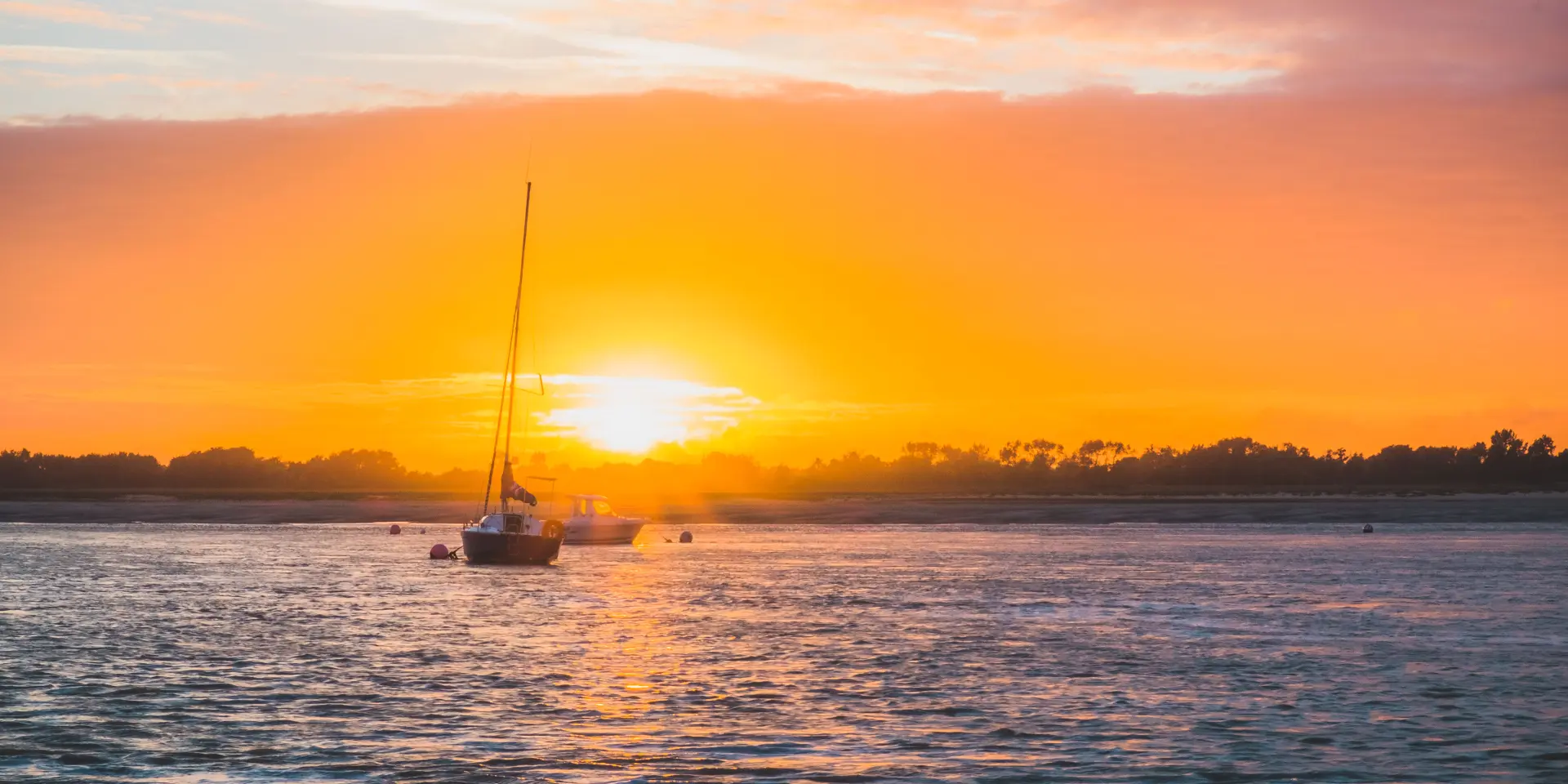 Un bateau à voile sur l'eau au coucher du soleil