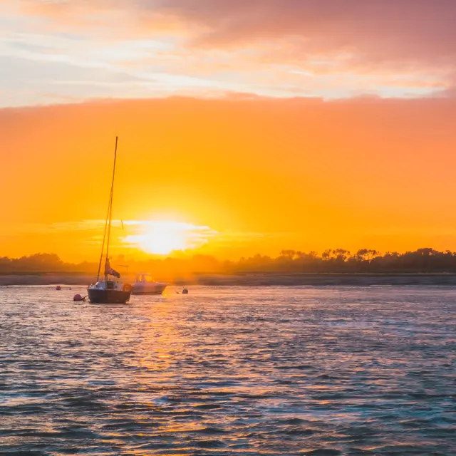 Un bateau à voile sur l'eau au coucher du soleil
