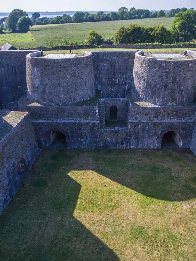 Vue aérienne d'une forteresse en pierre avec des murs épais et des tours rondes
